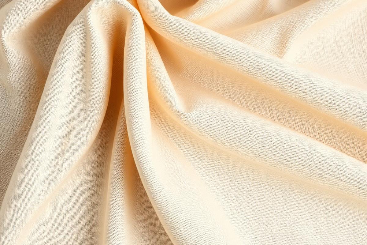 Macro texture of folded organic cotton and recycled silk in warm beige